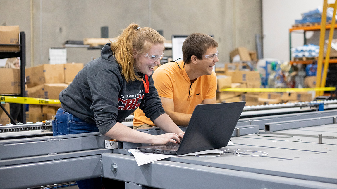 Two high school students work in the shop