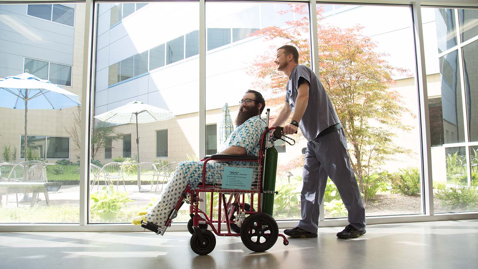 A nurse pushes a patient in a wheelchair